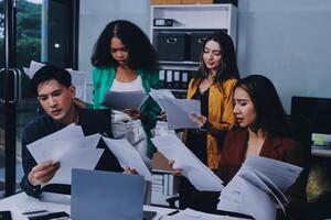 Stress, business people and employee frustrated with multitasking, pressure or overworked by team in chaos with paperwork. Anxiety, headache and worker overwhelmed by group and burnout in crisis photo