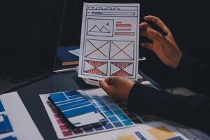 The designer team is designing the uxui system to make the uxui system work well on new phones and support system updates. Website development concept UI UX front end designer photo