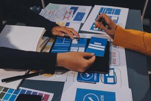 The designer team is designing the uxui system to make the uxui system work well on new phones and support system updates. Website development concept UI UX front end designer photo