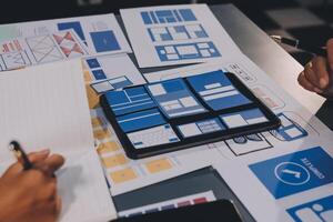 The designer team is designing the uxui system to make the uxui system work well on new phones and support system updates. Website development concept UI UX front end designer photo