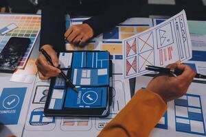 The designer team is designing the uxui system to make the uxui system work well on new phones and support system updates. Website development concept UI UX front end designer photo