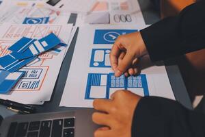 The designer team is designing the uxui system to make the uxui system work well on new phones and support system updates. Website development concept UI UX front end designer photo