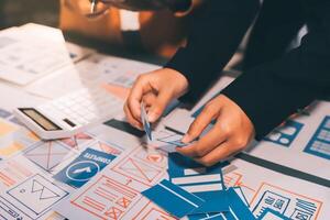 The designer team is designing the uxui system to make the uxui system work well on new phones and support system updates. Website development concept UI UX front end designer photo