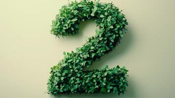 The number 2 is framed by a series of green leaves solid background photo