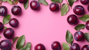 Plum fruit rounded border frame and green leaves decoration on pink background photo