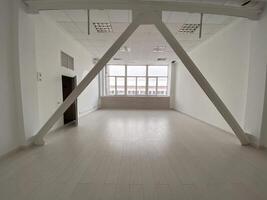 Empty modern loft room with large windows and structural beams, highlighting a spacious and bright interior. Room minimalist design for various uses and creativity. photo