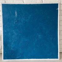 Textured deep blue panel is set against a white brick wall, emphasizing its rich color and intricate surface patterns. This composition reflects a perfect blend of modern art and minimalistic design photo