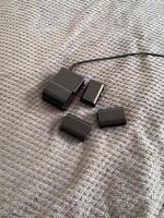 Set of camera batteries and a charger lie neatly arranged on a textured gray surface, ready for use. This image portrays a sense of preparation and practicality in the world of photography, photo