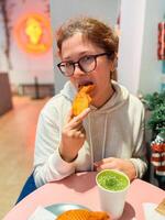 Woman with Japanese sweet taiyaki dessert. Freshly baked fish shaped waffle instead of filling adding ice cream. Winter and Christmas holidays sweets photo