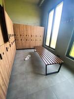 Wooden bench in empty locker room at gym photo