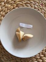 Broken fortune cookie with a blank paper slip on a gray background. Moment of anticipation and mystery that accompanies the opening of a fortune cookie photo