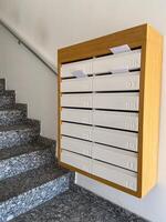 Row of mailboxes in a modern apartment building, with letters sticking out, symbolizing communication and daily life. Blend of functionality and design, capturing the essence of urban living photo