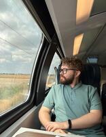 Man traveler enjoying a serene view from a train window. Calm and reflection during a peaceful journey photo