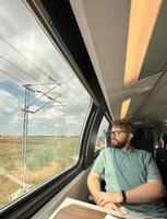 Man traveler enjoying a serene view from a train window. Calm and reflection during a peaceful journey photo