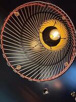 An artistic ceiling light fixture with intricate rope design, lamp. Warm, glowing bulb creates a cozy ambiance and striking visual effect photo