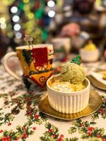 Festive dessert table with holiday-themed decorations. a warm crumble topped with a scoop of ice cream and a Christmas tree decoration captures the cozy atmosphere of a winter celebration. Xmas treats photo