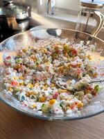 Imitation crab salad with crab sticks, corn, eggs, cucumber and rice in bowl. Top view close up photo