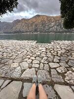 Restful moment by the lake with scenic mountain backdrop and cloudy sky. Tranquil scene highlighting the beauty of nature and personal reflection photo