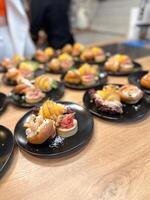 Gourmet appetizers elegantly arranged on black plates. Colorful presentation and variety of flavors, luxurious dining experience. Food and buffet concept photo