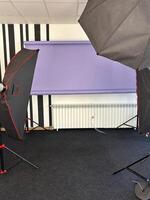 Professional photography studio setup with lighting equipment and a purple backdrop. the studio is well-equipped and ready for a photo session or recording