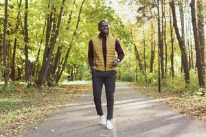 Male student walking in the park in autumn season photo