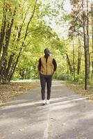 Male student walking in the park in autumn season photo