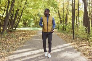 African american student walking in the park in autumn season photo