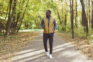 African american student walking in the park in autumn season photo