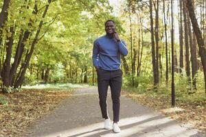 African american student walking in the park in autumn season photo