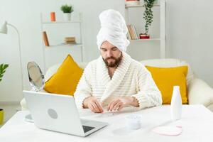 Bearded man sitting with eye patches on his face. Wrinkles and face home care for men. photo