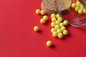 Homeopathy vitamins are scattered on a red background with a copyspace place for text. photo