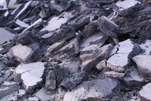 Close-up chunks of asphalt lie in a heap view from above. Road repair works photo