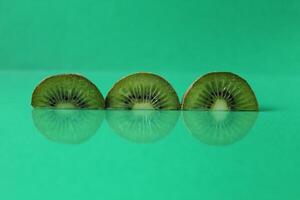 Green still life circles semicircular kiwi pieces with flipped on green with copyspace photo