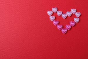 heart of rhinestone hearts on a red bright background with a copy of the space place for text valentine's day photo