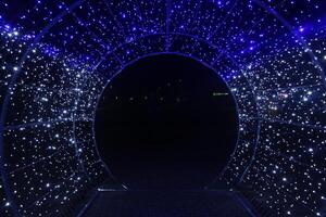 tunnel and illuminations of blue white on a black dark background. New Year's Eve Christmas. Photoona festive atmosphere. photo