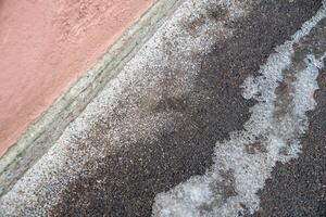 Deicing chemicals on pavement in winter. Salt grains on icy sidewalk paving slab with technical salt photo