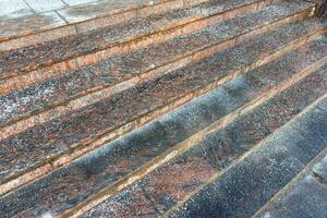 Deicing chemicals on stairs in winter. Salt grains on icy stone steps in cold season photo