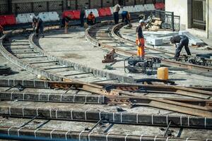 Workers team engaged in rail welding, tram track repair. Urban redevelopment, routes upgrade photo