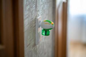 Mosquito repellent with plug into the socket at home. Electric insect repellent diffuser closeup photo