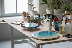 Completed epoxy resin art pieces on table in home loft studio. Round paintings with seaside waves photo