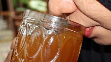 Close up cropped image thirsty woman holding glass drinks photo
