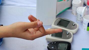 Hands checking diabetes and hyperglycemia with digital blood sugar meter photo