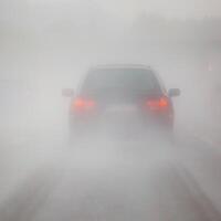 a car driving through a foggy road photo