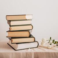 a stack of books on a table with flowers photo