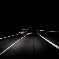 black and white photo of a highway at night
