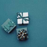 three gift boxes with bows on a blue background photo