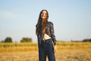 A Joyful Young Woman Smiling Brightly in a Beautiful Sunlit Field Glowing with Light photo