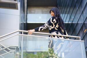 Sensual dancer turning to look down from urban viewpoint photo