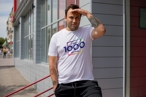 Young man in a white t-shirt with a colorful design stands in front of a building. psd