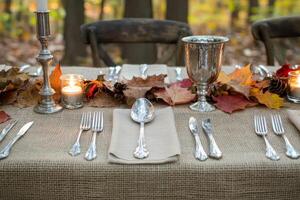 Rustic Outdoor Table Setting with Silverware and Autumn Leaves photo